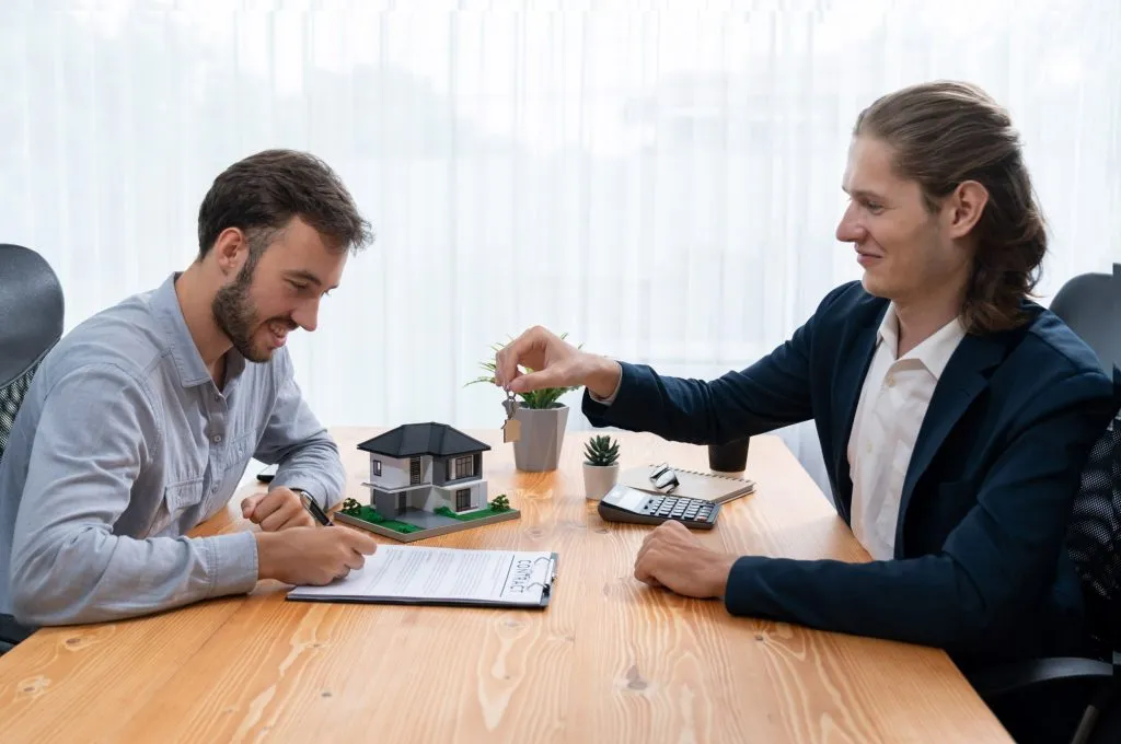 A property professional handing over a house key